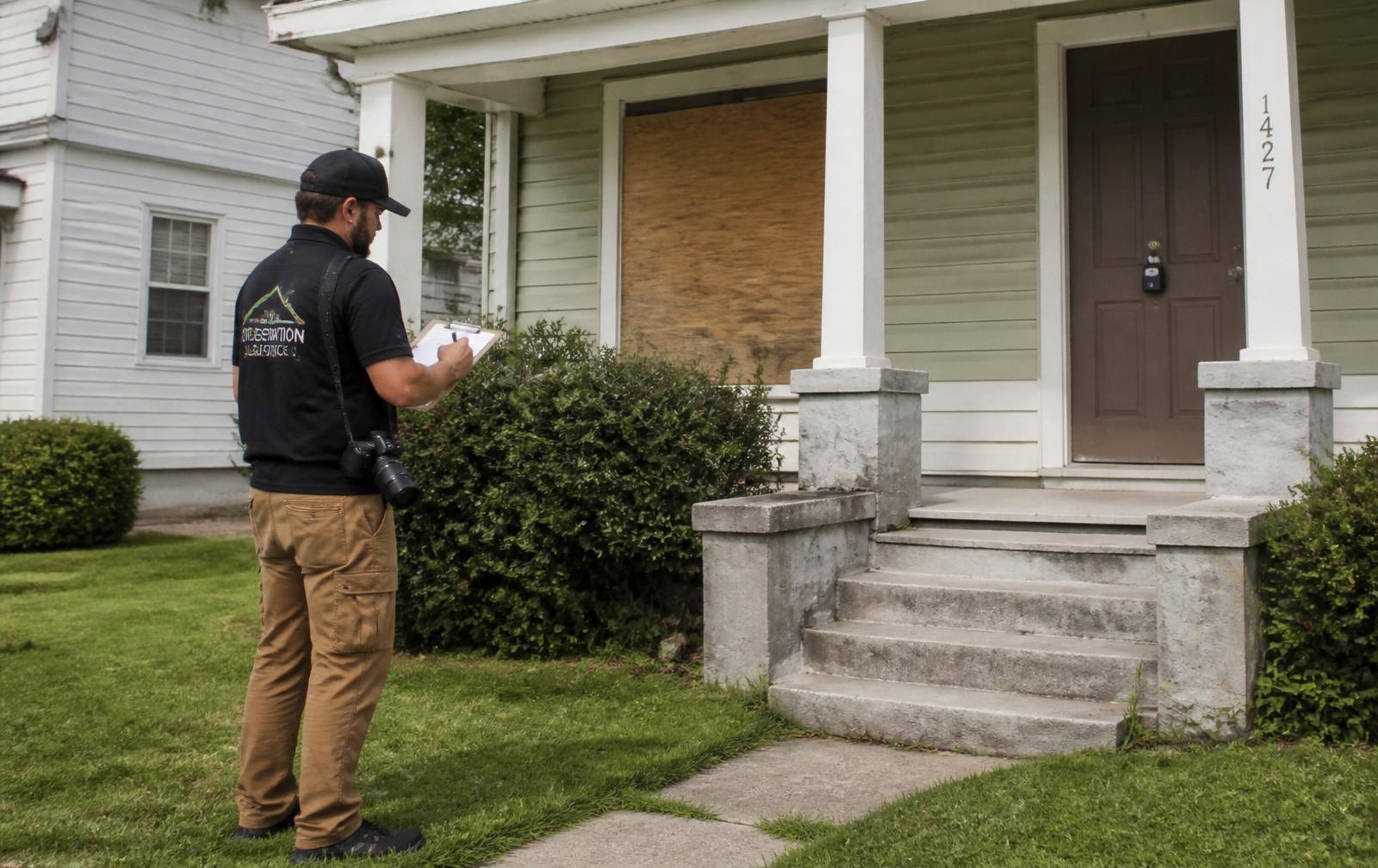 CP Property Solutions field technician installing a lockbox on a vacant Jacksonville property